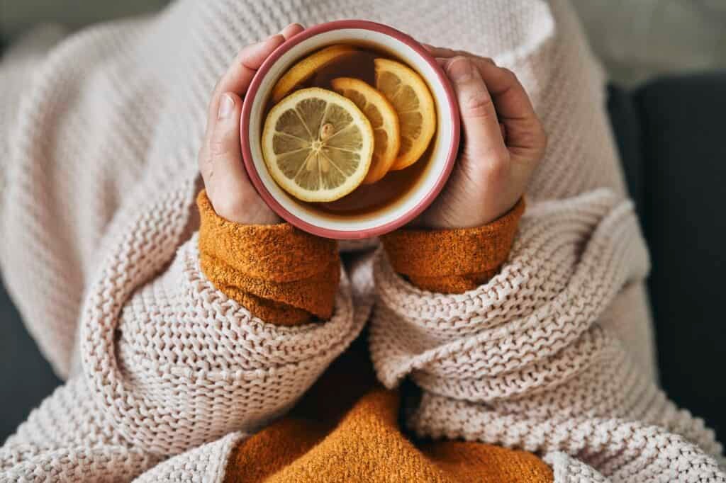 Top view of woman holding cup of hot tea