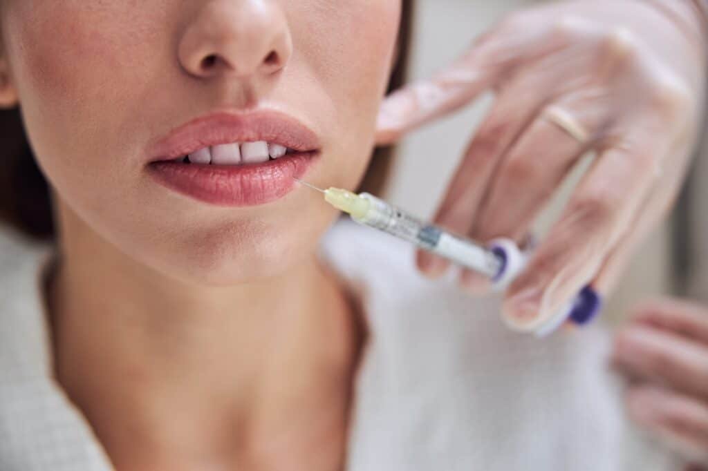 Charming female getting mouth contouring with filler injection