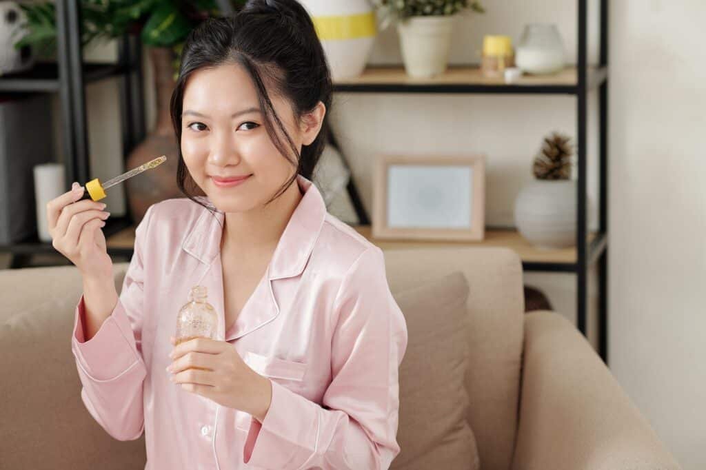 Woman applying serum with vitamin c