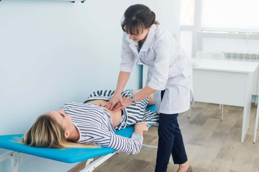 Doctor checking the stomach of one of her patients