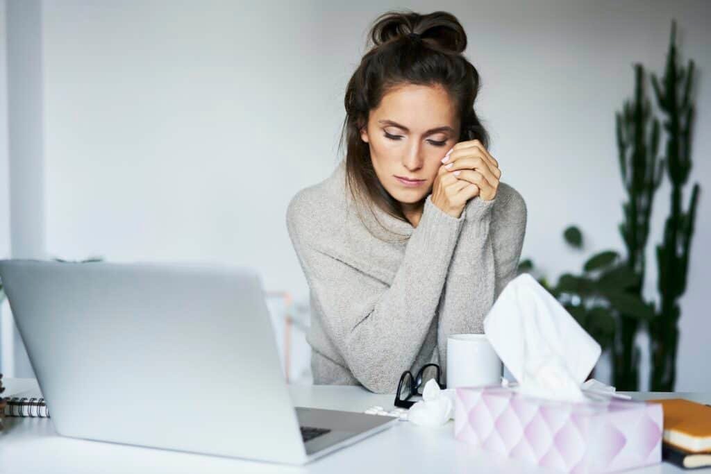 Ill woman working at home at desk