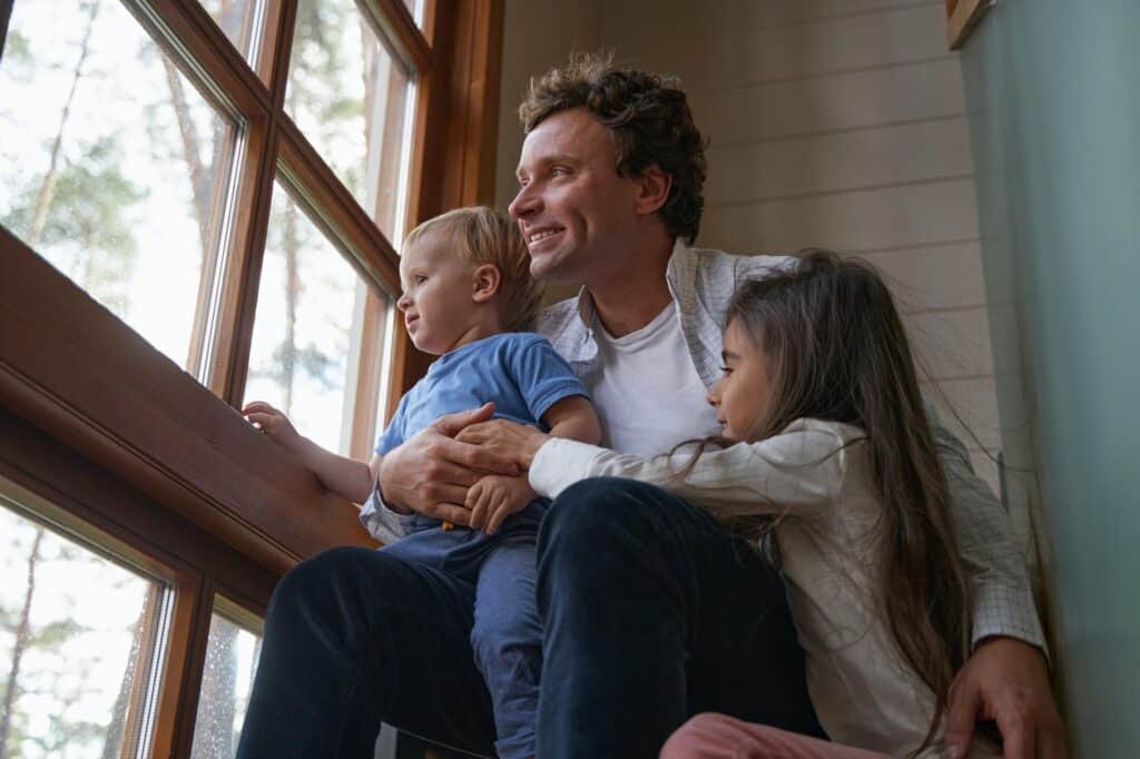 Close up of happy man embracing his children