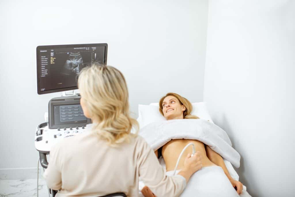 Doctor performs ultrasound examination of a woman