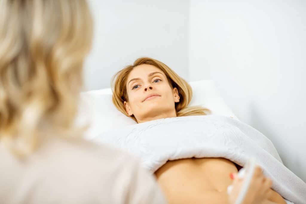 Woman examining her abdomen with ultrasound
