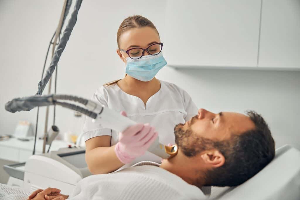 Unshaven young man undergoing laser hair removal procedure