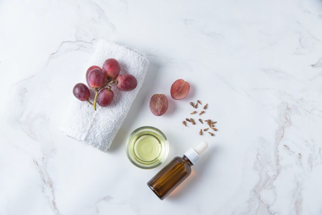 Flat lay is made of natural grape seed oil on white marble background. Natural cosmetics