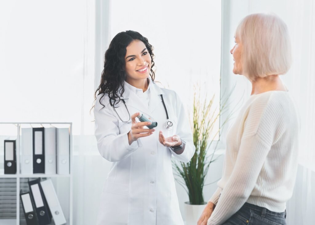Physician showing mature woman blue asthma inhaler