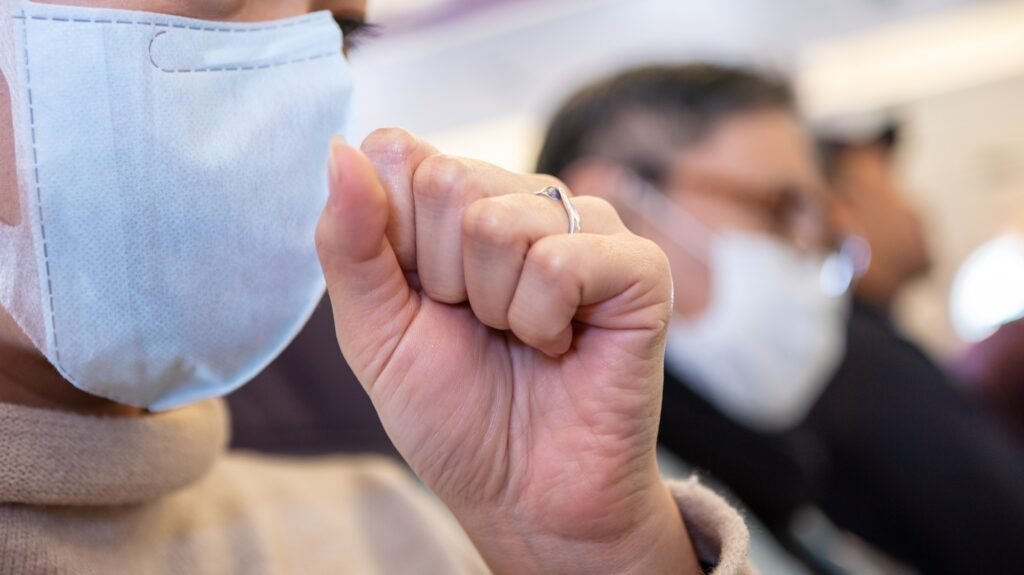 Asian woman passenger coughing over surgical mask to prevent omicron coronavirus
