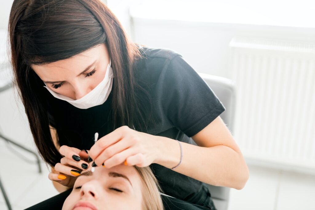 Pretty girl getting brow depilation at beauty salon