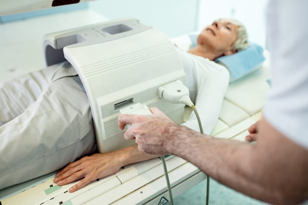 Unrecognizable radiologist preparing patient for abdomen MR scan.