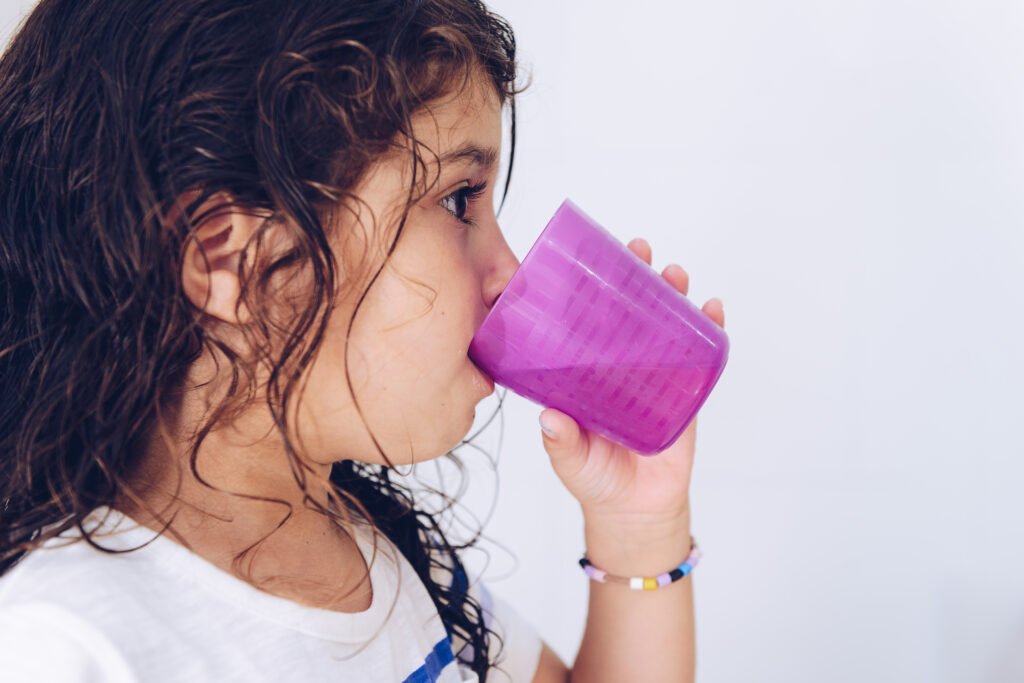 little girl rinsing her mouth after brushing teeth