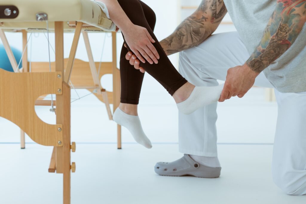 Physiotherapist touching the injured foot of a patient