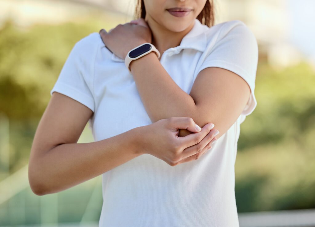 Tennis elbow, sports and a woman with injury, fitness and training game on court. Workout, sport ex