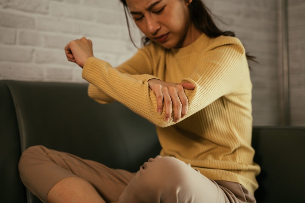 Young female suffering from elbow pain