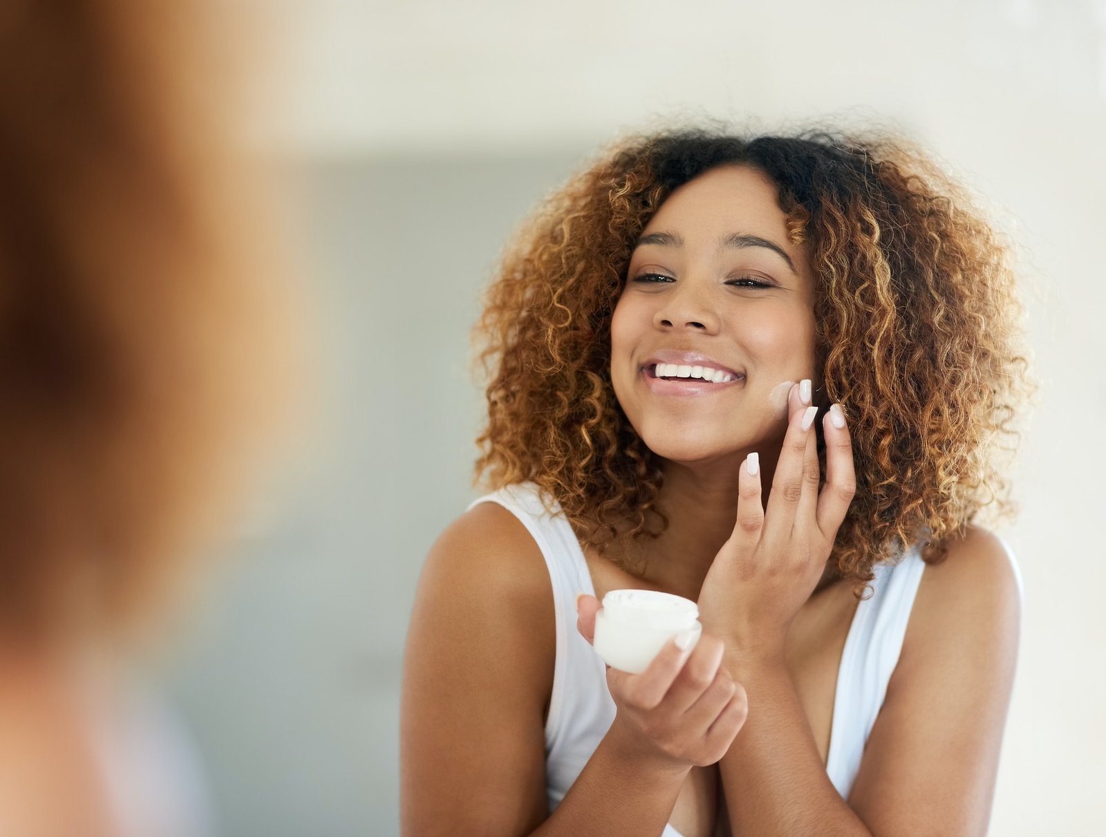 Use a product thatll save you some time. Shot of a young woman applying moisturizer to her face.